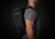 Person wearing a black backpack against a dark background