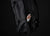 Black backpack with a protein bar inside on a black background