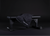 Black weight bench with a black towel draped over it on a dark background